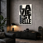 La Vie Est Belle glass wall art by Artdesigna displayed in a corner setting